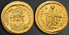 Byzantine Justinian I AD 527-565. Constantinople Solidus AV 21 mm, 4,49 g D N IVSTINI-ANVS P P AVG, helmeted and cuirassed bust facing, holding globus cruciger and shield / VICTORI-A AVGGG Γ, Angel st