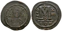 Ancient Byzantine Coins - Justinian I - Portrait Follis 527-565 AD. Constantinople mint. Obv: DN IVSTINIANVS PP AVG legend with helmeted and cuirassed bust facing, holding cross on globe and shield; c