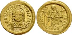Byzantine Coins JUSTINIAN I (527-565). GOLD Solidus. Constantinople. Obv: D N IVSTINIANVS P P AVG. Helmeted, draped and cuirassed bust facing, holding globus cruciger and shield with horseman motif. R