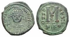 Justinian I Æ Follis. Justinian I Æ Follis. Nicomedia year 29 (555/6). Helmeted and cuirassed facing bust, holding globus cruciger and shield; cross to r. / Large M; cross above, A/N/N/O X/X/Ч/II/II a