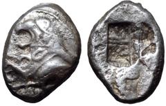 Greek Karia, uncertain mint AR Trite. Circa 500 BC. Forepart of lion with open jaws standing left before sunburst; in front, forepart of boar with legs extended left / Irregular rough incuse markings.